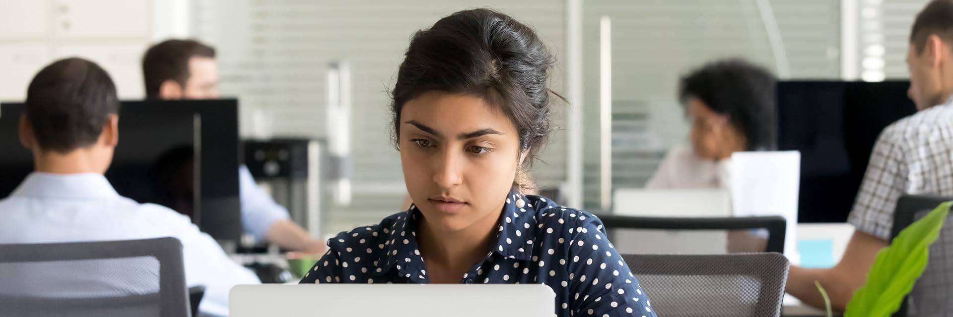 A woman staring at a computer screen. Confirmation of payee helps you confirm recipient details.
