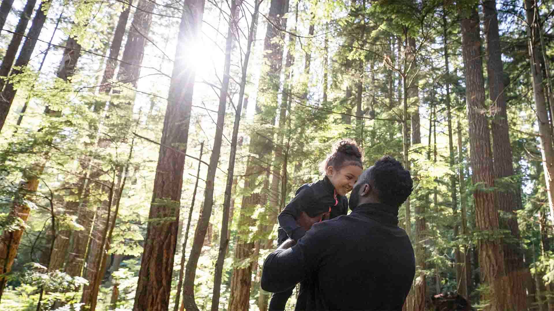 A man bonding with his daughter in a forest. The hospitality sector is recovering post-COVID.
